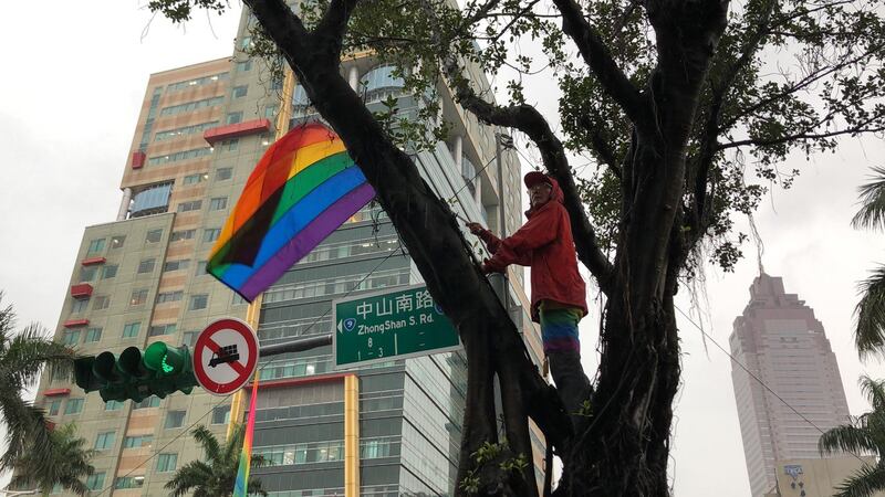 游行现场祁家威总会寻求制高点挥舞彩虹旗。(记者夏小华摄)
